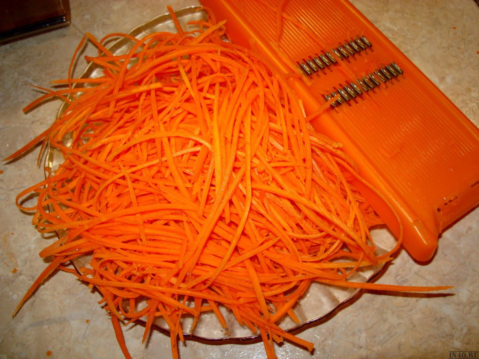 С моркови снимите верхний слой, натрите на специальной терке с насадкой для приготовления овощей по-корейски. При отсутствии данной терки можно воспользоваться обычной, но с крупными отверстиями. Стружку моркови закиньте на масляную сковороду, пассеруйте 